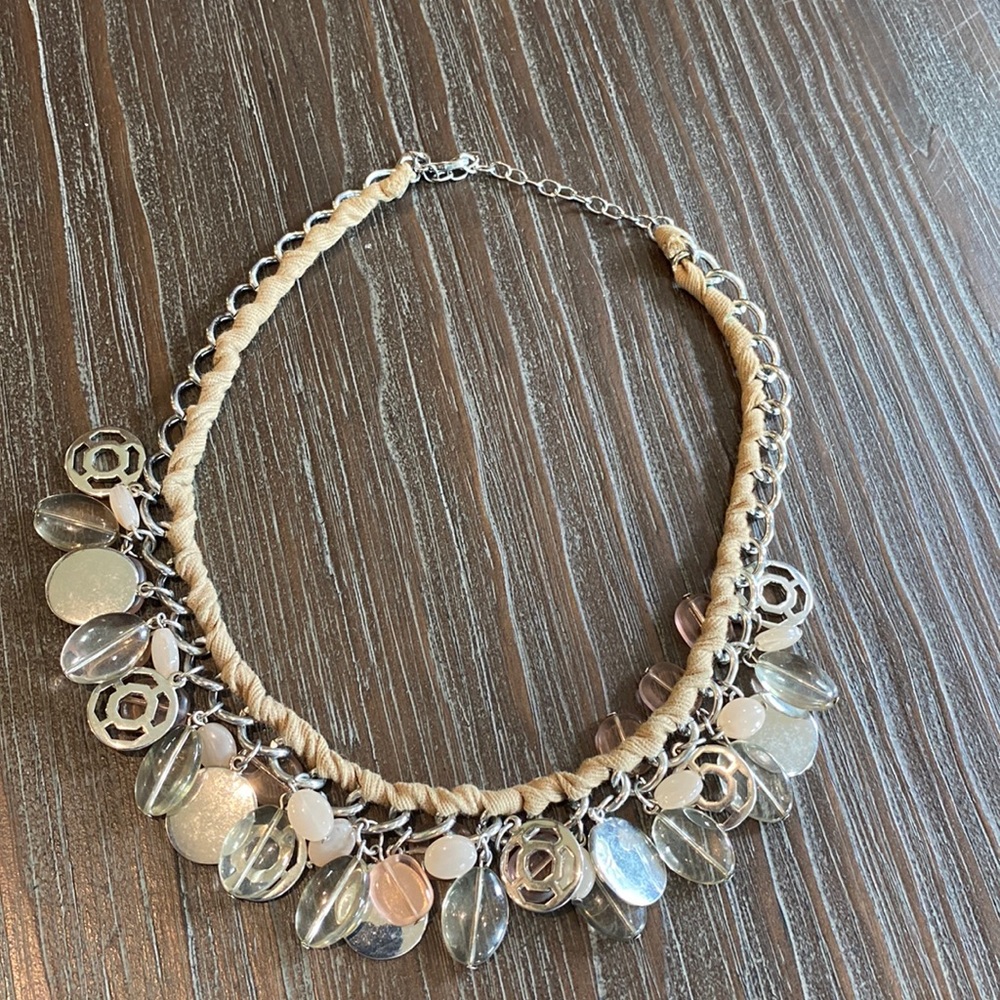 Nygard necklace intertwined with ribbon and silver and pink bangles.